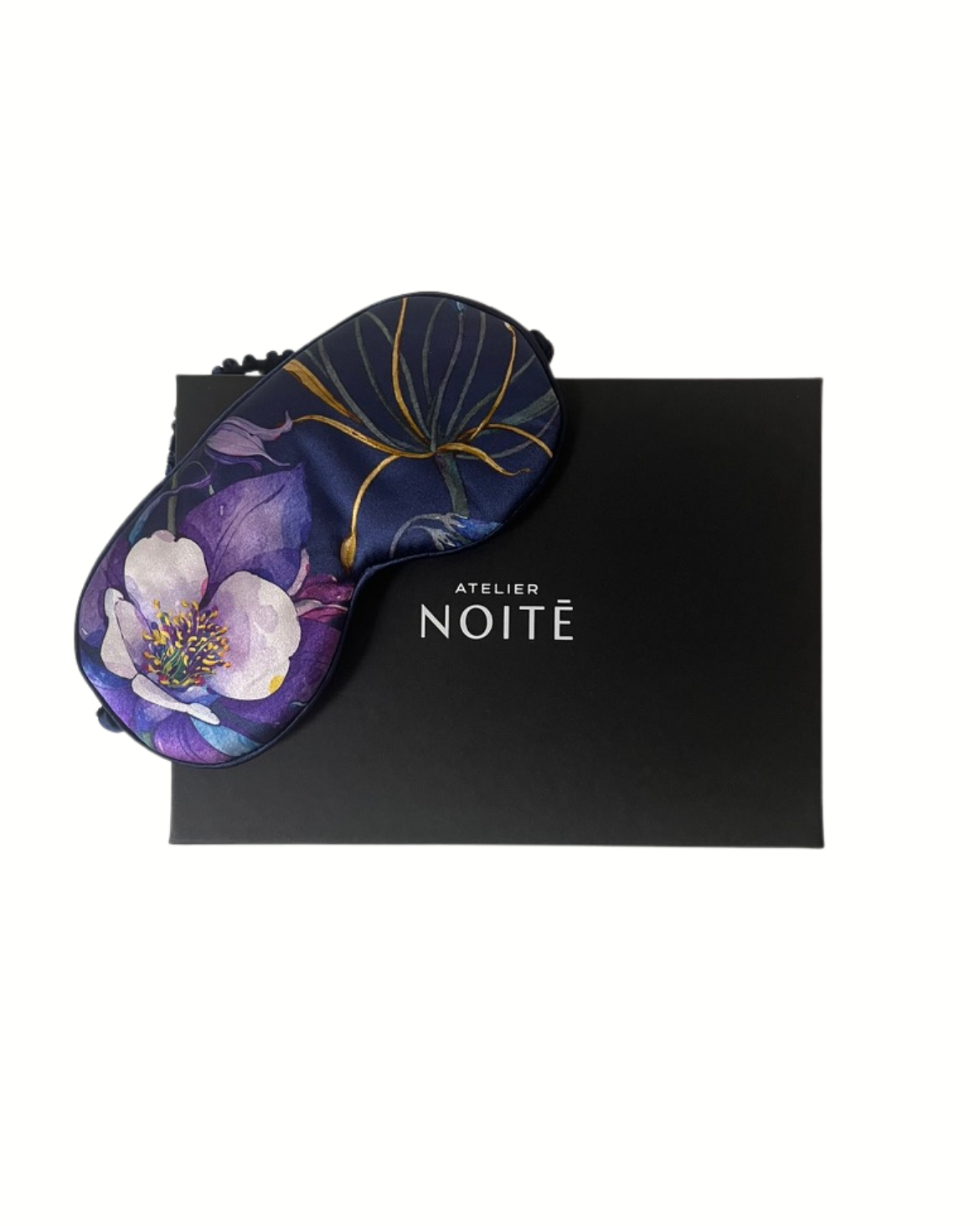 Floral eye mask on a black box with 'Atelier de Noite branding