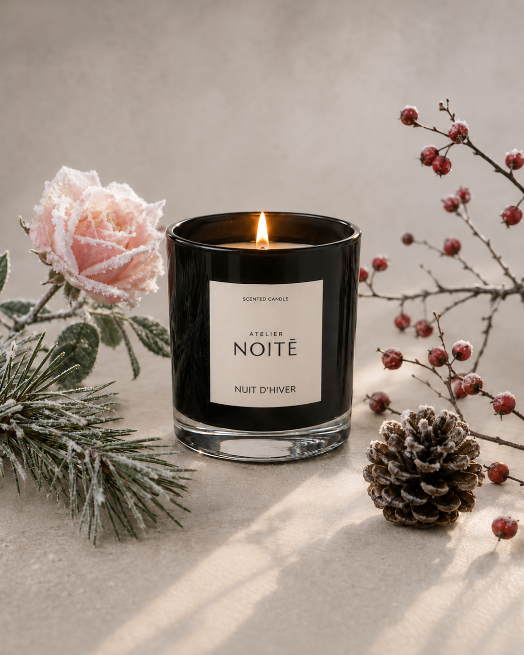Nuit D'Hiver Candle with a botanical still life featuring a winter rose, pines, and winter berries
